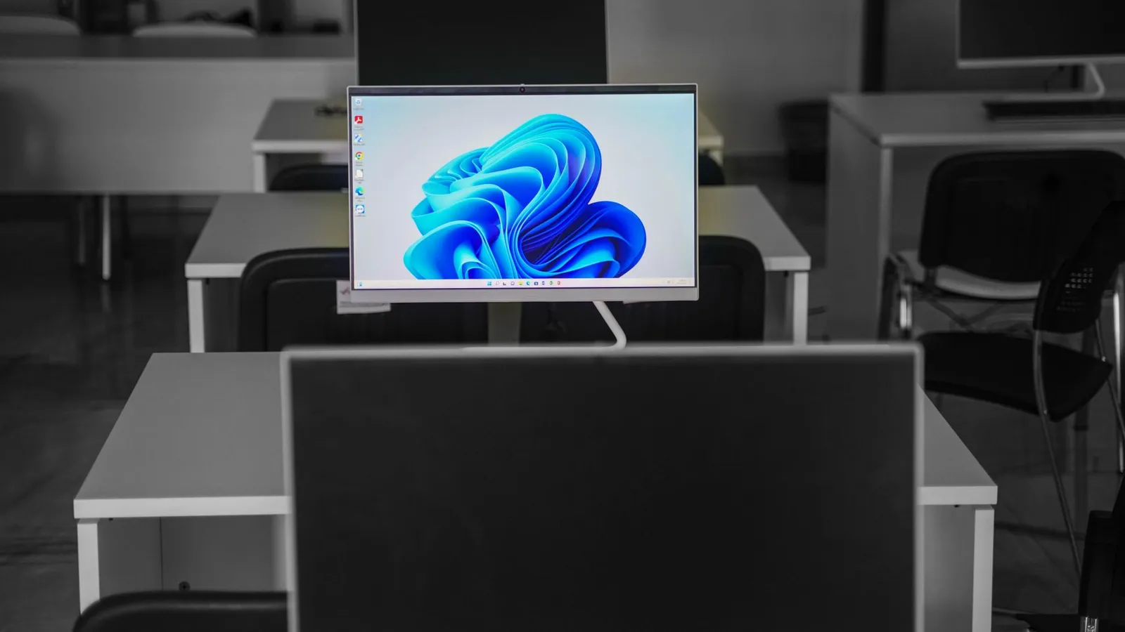 A contemporary office setup featuring computers on desks with modern flat screens.