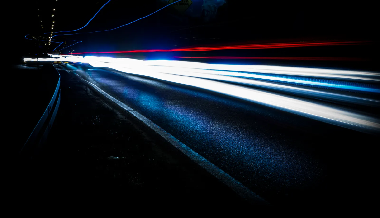 Long exposure of vibrant light trails on a highway at night.